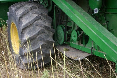 To protect the combine and save clean up time, a heavy piece of rubber is clamped on the frame....