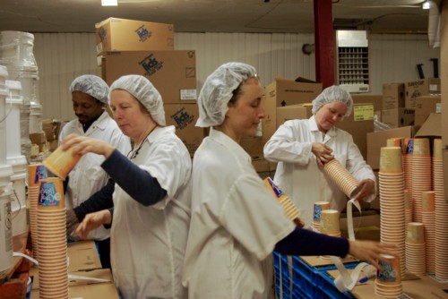 (from left) Errol, Leslie, Monique and Christina prepare the Cool Hemp Tubs for filling by writing the date code on the bottom and sticking on the little white Omega 3 and Omega 6 labels on each of 11,000 tubs.